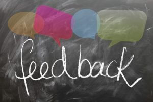 The word Feedback surrounded with empty speech bubbles