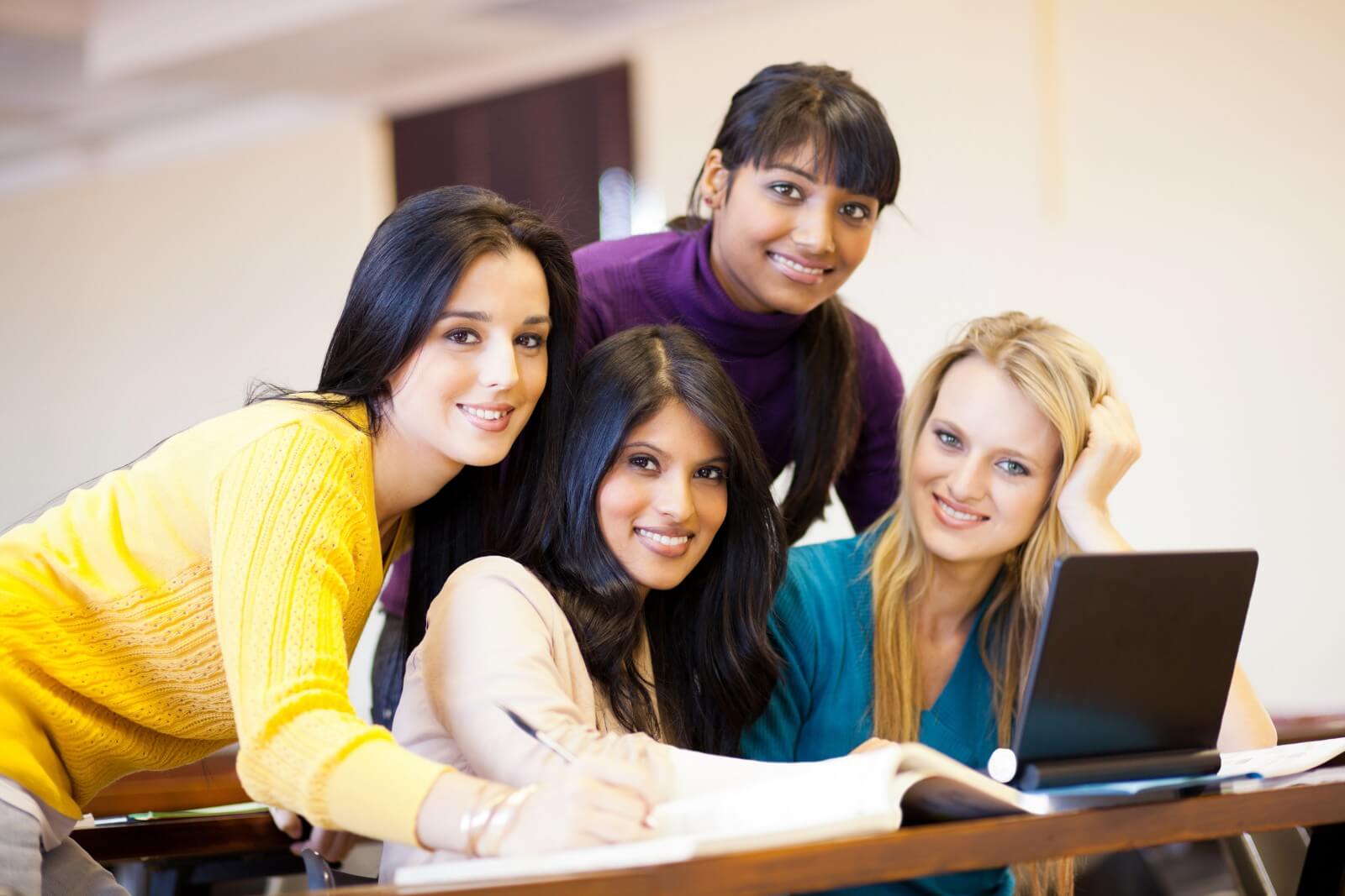 group of young female college students using laptop